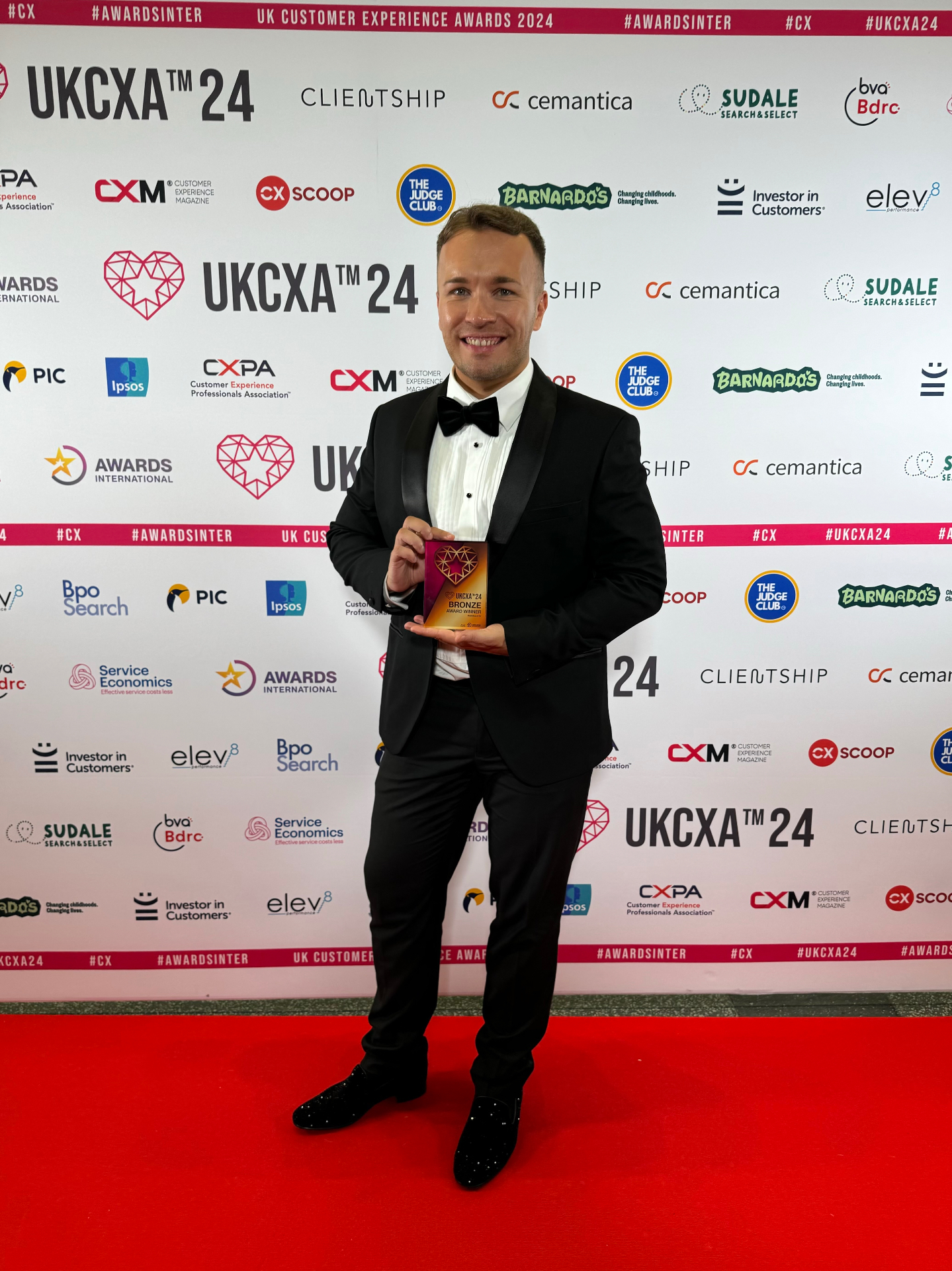 Shaun Hodge holding the Bronze award at the UK Customer Experience Awards, Wembley 2024